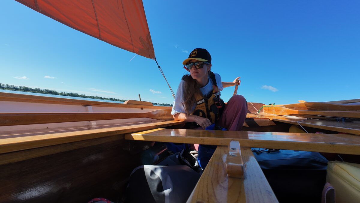 Gwenn à la barre de Méaban, voile orange gonflée